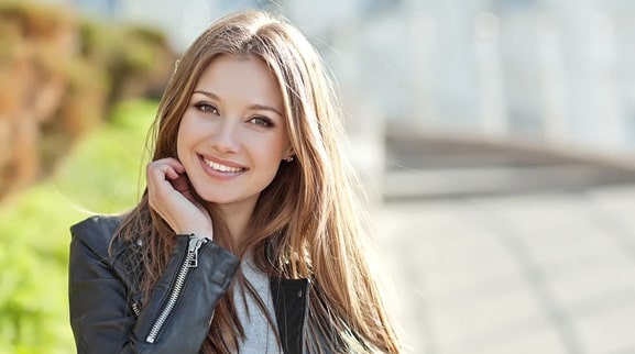 beautiful young woman in leather jacket showing off her amazing smile