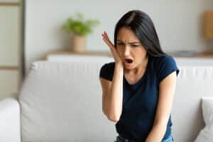Woman touching her jaw in pain from a fractured tooth