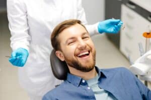 Man smiling at the dentist after getting CEREC tooth restoration
