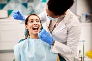 Woman having a comprehensive dental exam to maintain the future health and appearance of her teeth.